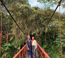 Crossing the red bridge in Bogor Botanical Garden